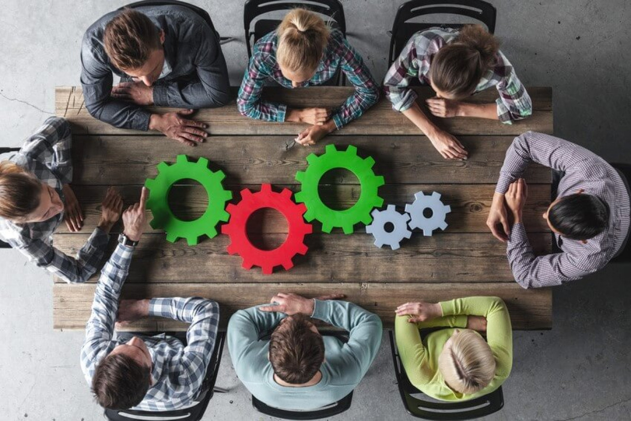 Hipster business team and cogs brainstorming planning meeting concept