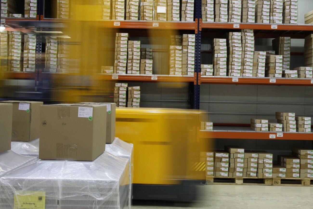 Gabelstapler fährt durch Lagerhalle voller Verpackungen